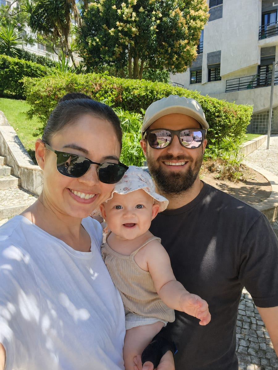 Elliot and Annie with their daughter Rozalie, outdoors in Lisbon.